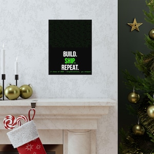 May include: A black and green poster with the words "BUILD. SHIP. REPEAT." in white and green text. The top of the poster has a green, pixelated background. The bottom of the poster reads "// class of 2020 - congratulations, you shipped."