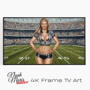 May include: Artwork of a woman in a referee uniform standing on a football field. The woman is wearing a black and white striped shirt and black shorts. The background shows a stadium filled with spectators. The artwork is framed.