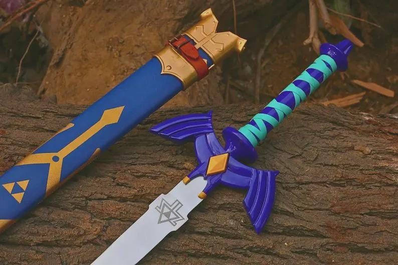 Puede incluir: Una espada azul y dorada con su funda a juego. La espada presenta una guarda morada con extensiones en forma de ala, un mango envuelto en azul cerceta y morado, y una hoja plateada grabada con un s&iacute;mbolo triangular. La funda tiene detalles dorados.