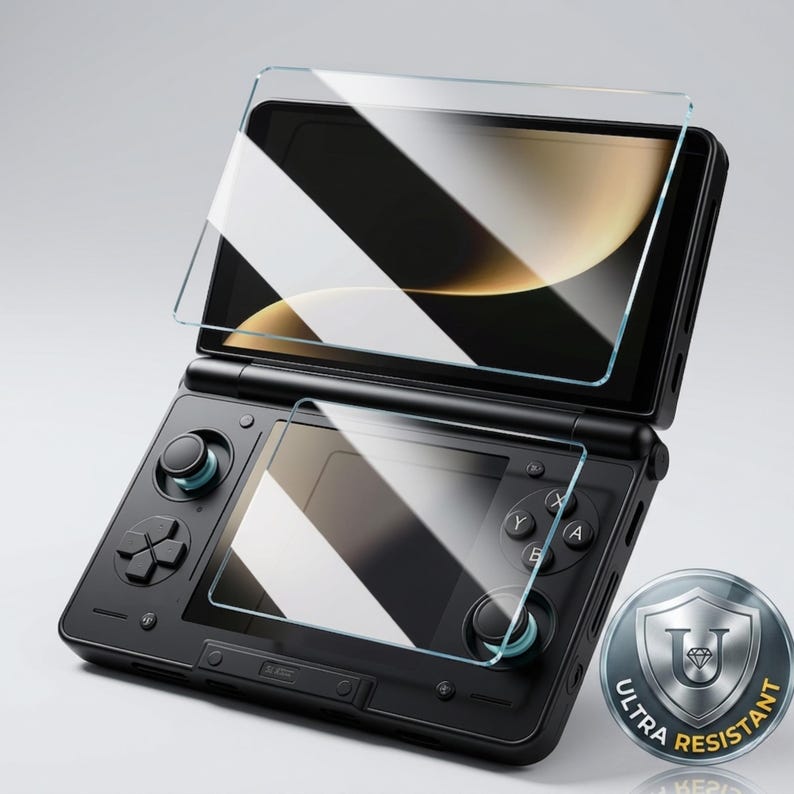 May include: A black handheld gaming console with a screen protector applied. The console features a D-pad, control sticks, and action buttons. A silver emblem with the text "ULTRA RESISTANT" is visible.