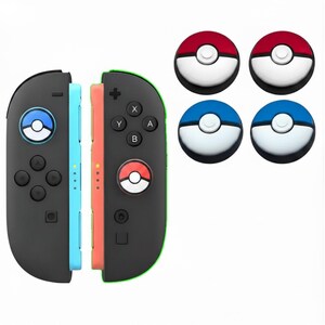 May include: Black and colored game controllers with matching button covers. The controllers have a blue and orange side, with a green trim. The button covers are red and white, and blue and white, with a circular design.