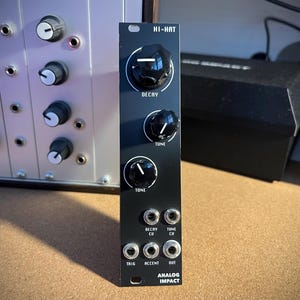 Peut inclure: Module de synthétiseur de musique électronique noir étiqueté "HI-HAT" avec trois boutons rotatifs étiquetés "DECAY", "TUNE" et "TONE". Il comporte plusieurs prises d'entrée et de sortie et le texte "ANALOG IMPACT". D'autres modules de synthétiseur sont visibles en arrière-plan.