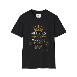 Könnte beinhalten: Schwarzes T-Shirt mit einem goldenen Kronen-Design und dem Text "All Things Are Working For My Good" mit dem Bibelvers Römer 8,28. Das T-Shirt hat einen Rundhalsausschnitt und ist aus weichem Stoff.