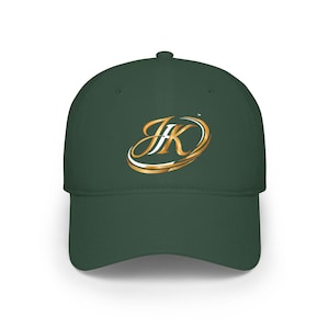 Peut inclure: Casquette de baseball vert foncé avec un logo "JK" doré et blanc. Le logo est entouré d'un motif tourbillonnant doré. La casquette a une visière incurvée et une couronne structurée.