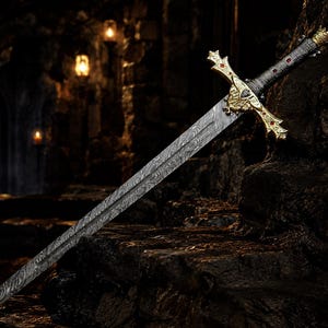May include: A sword with a patterned Damascus steel blade and a gold-coloured crossguard featuring red accents. The handle is black with gold-coloured metal details, including a crown-shaped pommel at the end of the grip.