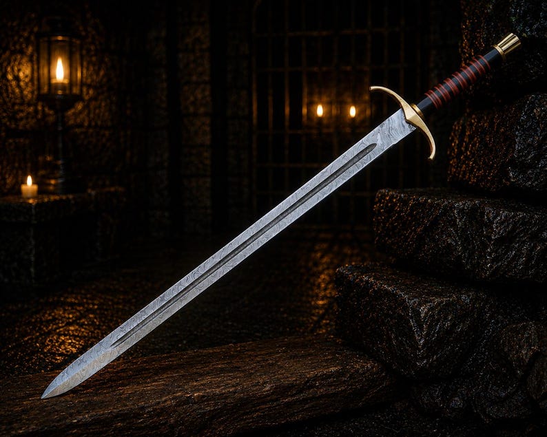 May include: A double-edged sword with a patterned steel blade, a gold-coloured crossguard, and a black handle wrapped with thin red bands. The pommel is gold-coloured, and the blade features a central fuller running down the length of the metal.