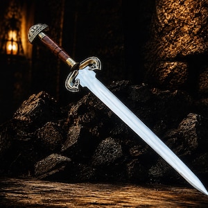 May include: A double-edged sword with a polished steel blade, a dark brown wooden grip, and an ornate brass crossguard featuring intricate scrollwork. The pommel is rounded with engraved metal detailing, completing the balanced design of this weapon.