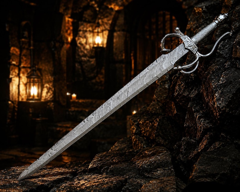 May include: A double-edged sword featuring a distinct wavy Damascus steel pattern on the blade. The hilt includes a silver-toned metal crossguard with curved quillons and a textured grip, showcasing intricate metalwork details on the pommel.