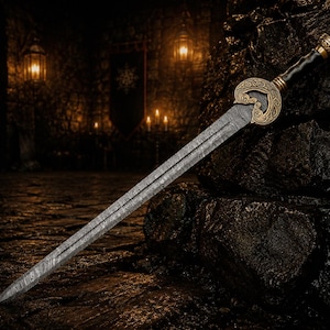 May include: A double-edged sword with a patterned Damascus steel blade, a dark handle, and an ornate gold-coloured metal crossguard featuring intricate swirling engravings. The blade is long and pointed, extending from the detailed hilt.