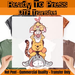 May include: A DTF transfer featuring a stack of cartoon characters, including Winnie the Pooh, Tigger, and Eeyore. The transfer is held in front of a white t-shirt. Text at the top reads "Ready To Press DTF Transfer".