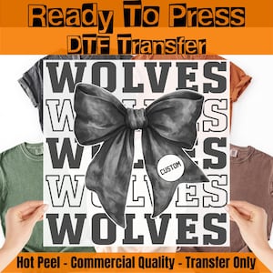 May include: A DTF transfer featuring the word "WOLVES" in a bold, block font, with a large bow graphic. The transfer is held up against a backdrop of t-shirts in various colors. The text "Ready To Press" and "Hot Peel - Commercial Quality - Transfer Only" is also visible.