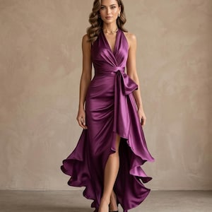 May include: A formal, floor-length, plum-colored satin dress with a halter neckline and a high-low hemline. The dress features a draped bodice with a bow detail at the waist. Black heels complete the look.