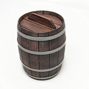 May include: A small, decorative wooden barrel with a lid. The barrel is brown with gray metal bands and a wooden lid. The lid has a handle for easy opening. The barrel is likely used for storage or decoration.
