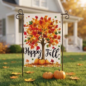 May include: A rectangular garden flag featuring a central tree with vibrant red, orange, and yellow autumn leaves. The text Happy Fall is written in black cursive script below the tree, with three orange pumpkins at the base of the trunk.
