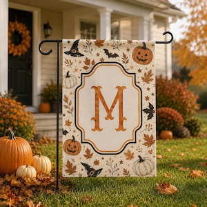 Peut inclure: Un drapeau de jardin rectangulaire avec un panneau central crème portant une grande lettre M orange dans une bordure décorative. Le fond est orné de citrouilles orange, de chapeaux de sorcière noirs, de chauves-souris et de feuilles d'automne.