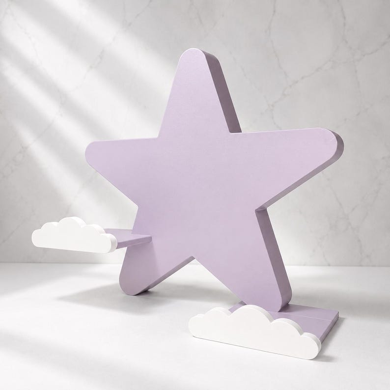May include: A lavender star-shaped shelf with two white cloud accents. The shelf is made of wood and has a sturdy base. The design is whimsical and suitable for a child's room or nursery.