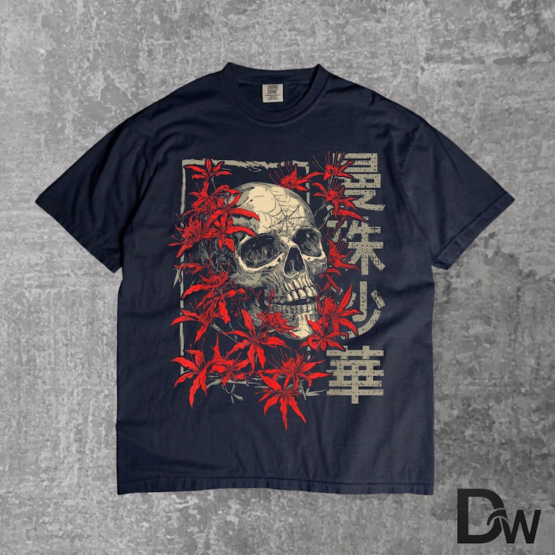 May include: Navy blue t-shirt with a skull graphic framed by red leaves. Japanese text is printed on the right side of the skull. The design is centered on the front of the shirt.