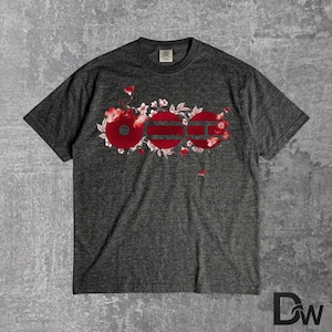 May include: Dark gray t-shirt with a floral design and the word "OGG" in red. The graphic features red flowers and white blossoms. The shirt has a crew neck and short sleeves. The fabric has a heathered texture.