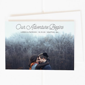 May include: A wedding announcement card with a photo of a couple embracing in a snowy forest. The text reads "Our Adventure Begins" with the couple's names, wedding date, and location.