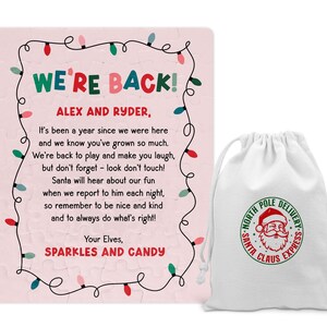 May include: A pink puzzle with the text "WE'RE BACK!" and a message to Alex and Ryder, framed by a string of colorful lights. A white drawstring bag with a Santa Claus Express logo is next to the puzzle.