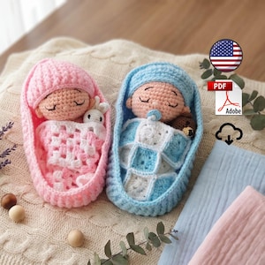 May include: Two crocheted dolls in bassinets, one pink and one blue. The pink doll wears a pink hat and is wrapped in a white and pink blanket with a small white toy. The blue doll wears a blue hat, has a pacifier, and a small brown toy.