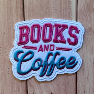 May include: An embroidered patch with a white background featuring the text BOOKS in bold magenta block letters, the word AND in smaller magenta letters, and the word Coffee in a teal cursive script with a dark magenta shadow effect.