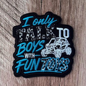 May include: A black embroidered patch featuring the text I ONLY TALK TO BOYS WITH FUN TOYS in bright blue and white leopard print lettering. The design includes a white embroidered graphic of an off-road vehicle or UTV next to the text.