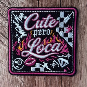 May include: A square embroidered patch with a black background and a pink border. The text reads "Cute pero Loca" in white script. The design includes pink and yellow flames, a white checkered pattern, a pink lip icon, a diamond, and stars.