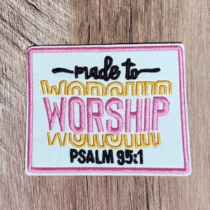 May include: A rectangular embroidered patch with a white background and a pink border. It features the black text "made to", the yellow text "worship" in a wavy font, the pink text "WORSHIP", and the black text "PSALM 95:1" at the bottom.
