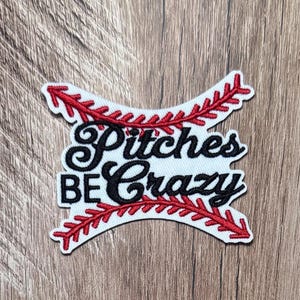 Può includere: Una toppa ricamata bianca con il testo nero Pitches BE Crazy in un carattere stilizzato e in stampatello. Il design è incorniciato da due motivi a cucitura da baseball rossi incrociati che si curvano lungo i bordi superiore e inferiore.