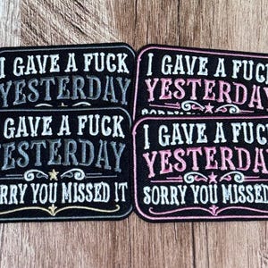 Puede incluir: Cuatro parches rectangulares bordados con fondo negro. Dos parches tienen texto blanco y gris que dice I GAVE A FUCK YESTERDAY. Dos parches tienen texto rosa y blanco que dice I GAVE A FUCK YESTERDAY SORRY YOU MISSED IT con detalles decorativos.
