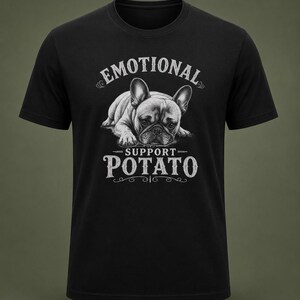 Może przedstawiać: Czarna koszulka z szczeg&oacute;łową ilustracją buldoga francuskiego. Tekst nad psem brzmi "EMOTIONAL", a pod nim "SUPPORT POTATO" w stylu vintage. Projekt jest w odcieniach szarości i bieli.