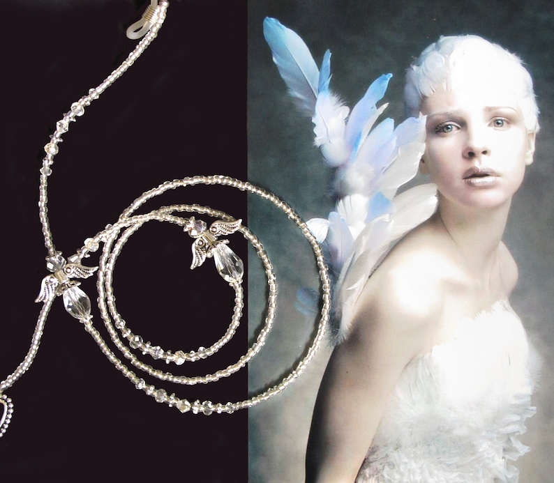 May include: A silver beaded necklace with angel wing charms. The necklace is layered and has a clasp closure.