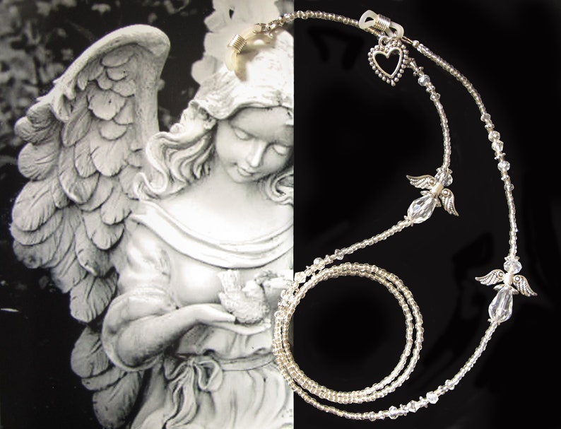 May include: A silver eyeglass chain with clear crystal beads and angel charms. The chain is double-stranded and has a heart charm at the top.