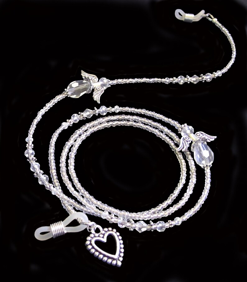 May include: A silver eyeglass chain with clear crystal beads and angel wing charms. The chain has a heart-shaped charm at the bottom.