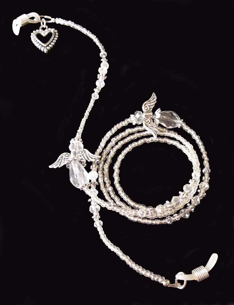 May include: A silver eyeglass chain with clear beads and angel wing charms. The chain has a heart charm at the top and clear bead accents.