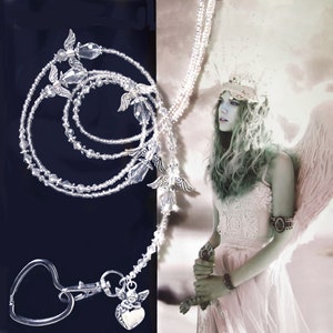 May include: A silver beaded lanyard with angel wing charms and a heart-shaped clip. The lanyard is layered with multiple strands of beads and features a crystal charm.