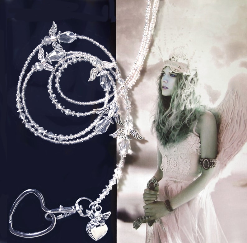 May include: A silver beaded lanyard with angel wing charms and a heart-shaped clip. The lanyard is layered with multiple strands of beads and features a crystal charm.