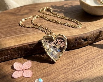 Collana con ciondolo a forma di cuore dorato e fiore pressato in resina, con veri fiori secchi, gioiello ispirato alla natura.