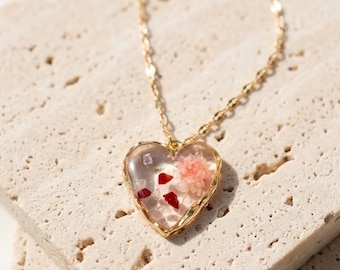 Collana con ciondolo a forma di cuore dorato e fiore pressato in resina, ciondolo botanico, gioiello ispirato alla natura