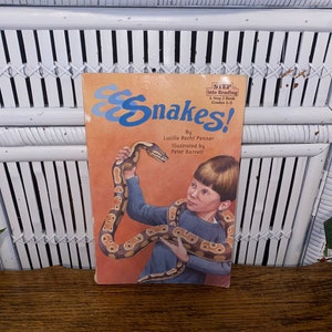 May include: A Step Into Reading book titled "Snakes!" by Lucille Recht Penner, illustrated by Peter Barrett. The cover features a young boy holding a snake.