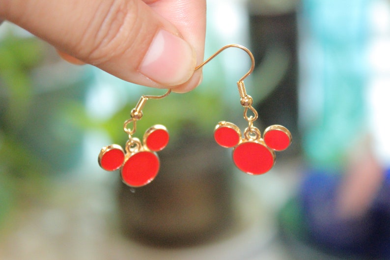 May include: Gold earrings with red Mickey Mouse head charms.