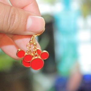 May include: Gold dangle earrings with red enamel Mickey Mouse heads.