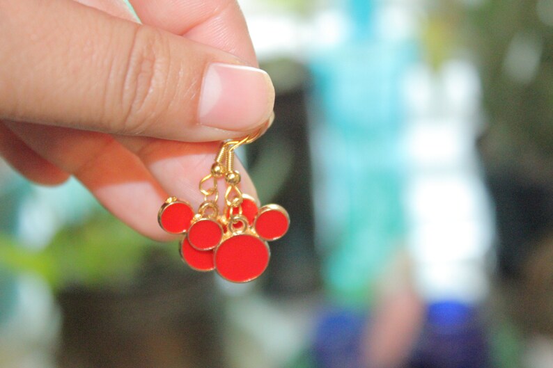 May include: Gold dangle earrings with red enamel Mickey Mouse heads.