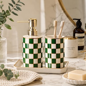 Conjunto de banheiro em cerâmica com padrão xadrez e dispensador de sabonete dourado.