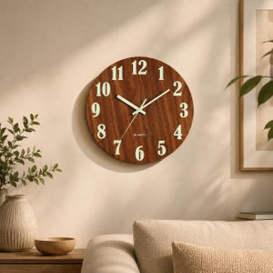 May include: A round wall clock with a dark brown wood grain finish. The clock face features large, pale green luminous Arabic numerals from 1 to 12 and matching luminous hour, minute, and second hands. The word QUARTZ is printed in small white text.