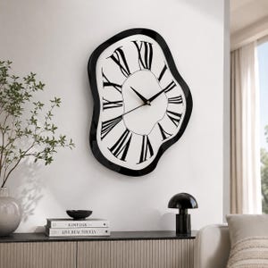 May include: A wall clock with an irregular, wavy black frame and a white face featuring black Roman numerals. The clock has three thin black hands at the center. The design has a distorted, melting appearance with a smooth, glossy finish.