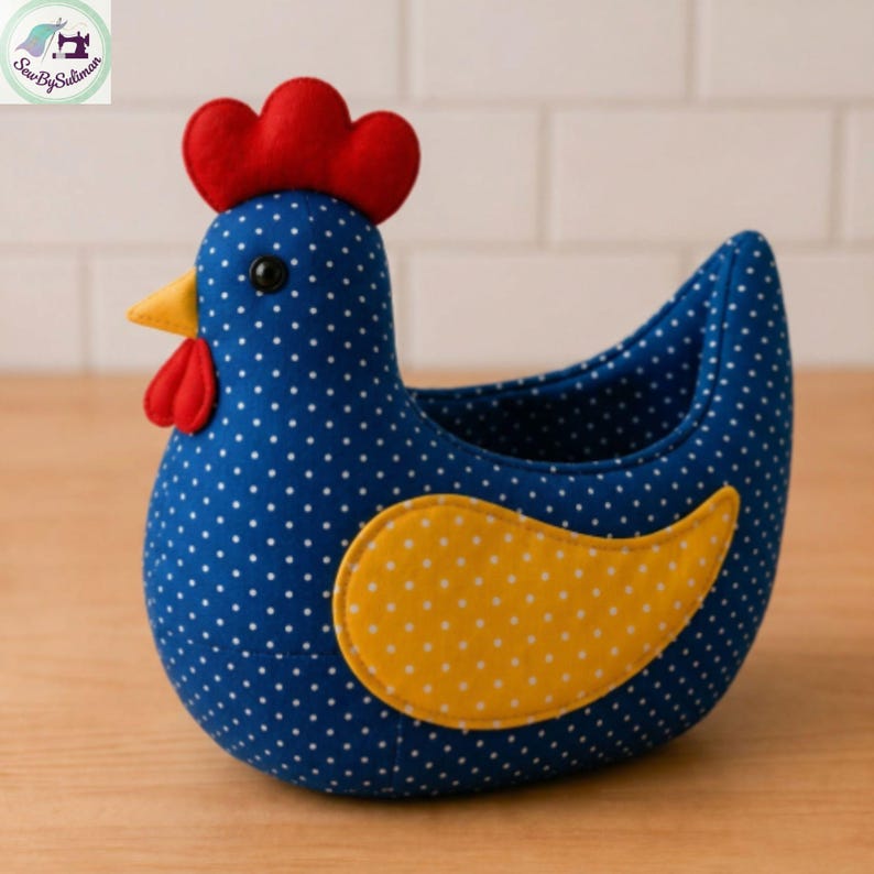 K&ouml;nnte beinhalten: Ein handgefertigter Korb in Form eines Huhns. Der K&ouml;rper ist blau mit wei&szlig;en Punkten und hat einen gelben Fl&uuml;gel. Es hat einen roten Kamm und Kehllappen, einen gelben Schnabel und ein schwarzes Auge. Der Korb ist f&uuml;r kleine Gegenst&auml;nde gedacht.