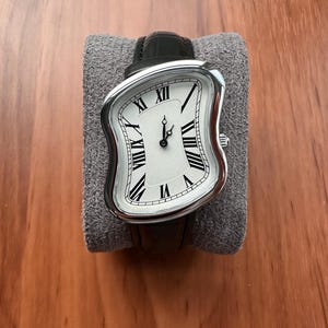Vintageklocka med smälta romerska siffror, silverfärgad boett, svart läderarmband, klocka i surrealistisk konststil