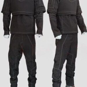 Pu&ograve; includere: Due completi tattici neri esposti su manichini. Ogni completo include un top a collo alto con protezione per il petto, maniche lunghe e pantaloni abbinati. Le cuciture bianche accentuano le cuciture. I completi sono abbinati a stivali marroni.